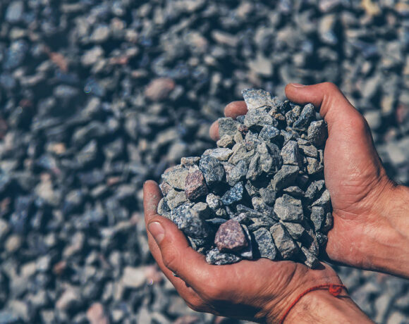 Crushed stones in the hands of a man. Selective focus. Nature.
